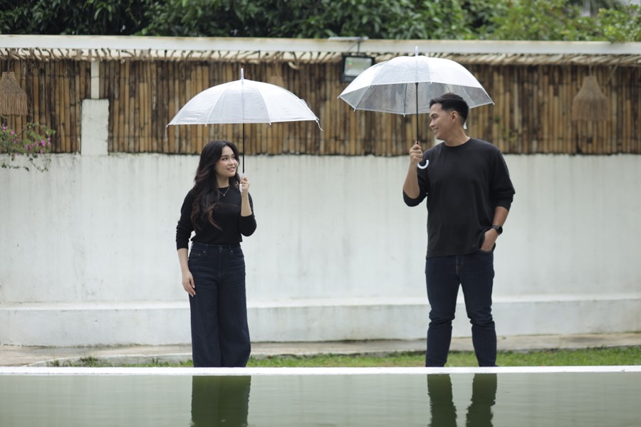 John and Alyssa with clear umbrellas by the reflecting pool